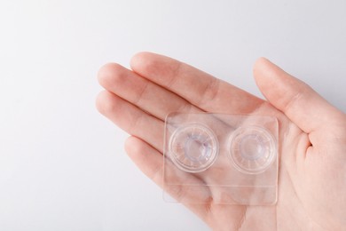 Photo of Woman with contact lenses on light background, closeup
