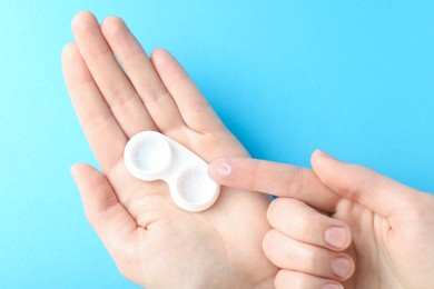 Photo of Woman with contact lenses on light blue background, closeup
