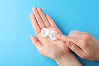 Photo of Woman with contact lenses on light blue background, closeup