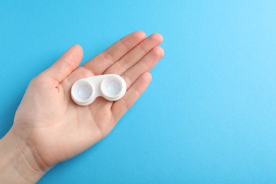 Photo of Woman with contact lenses on light blue background, top view. Space for text
