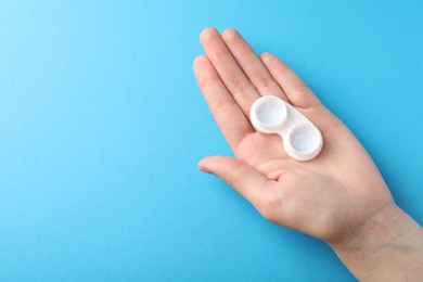Photo of Woman with contact lenses on light blue background, closeup. Space for text