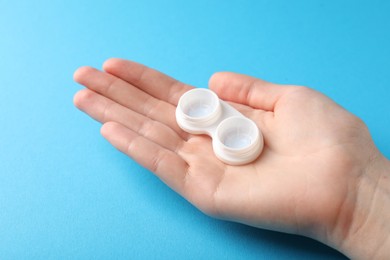 Photo of Woman with contact lenses on light blue background, closeup