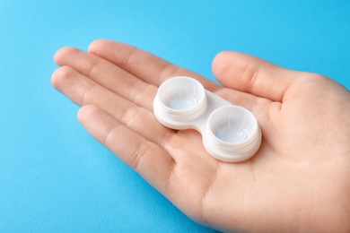 Photo of Woman with contact lenses on light blue background, closeup