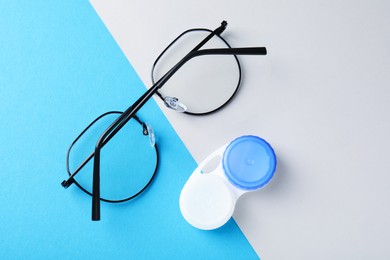 Photo of Case with contact lenses and glasses on color background, flat lay