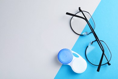 Photo of Case with contact lenses and glasses on color background, flat lay. Space for text