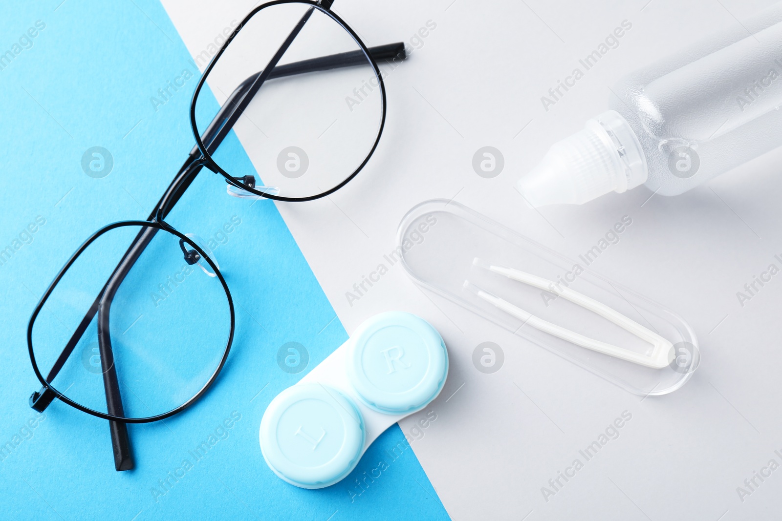 Case with contact lenses, glasses, tweezers and liquid solution on color background, flat lay Photo of Case with contact lenses, glasses, tweezers and liquid solution on color background, flat lay