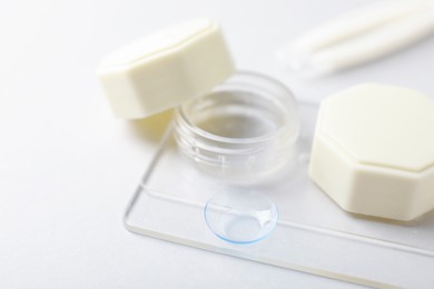 Photo of Case with contact lenses on white background, closeup