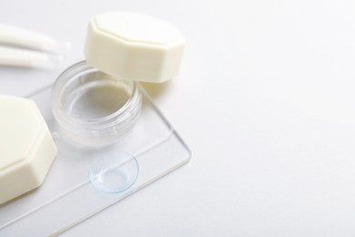Photo of Case with contact lenses on white background, closeup. Space for text