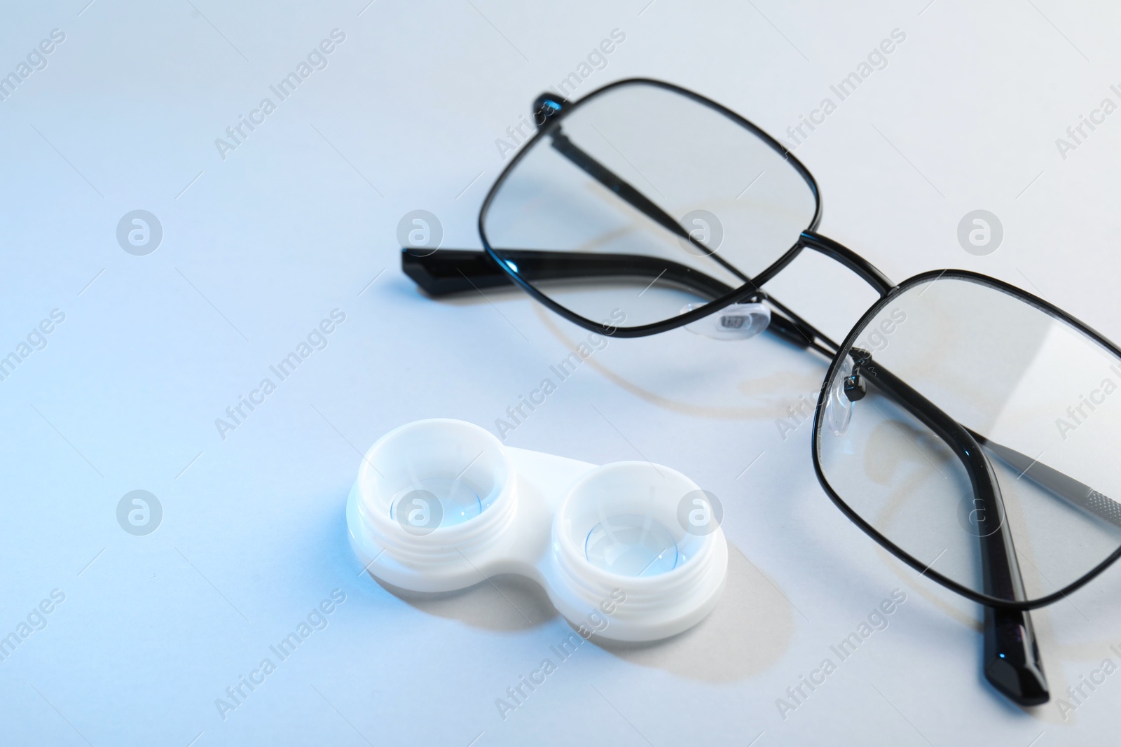 Case with contact lenses and glasses on white background, closeup Photo of Case with contact lenses and glasses on white background, closeup
