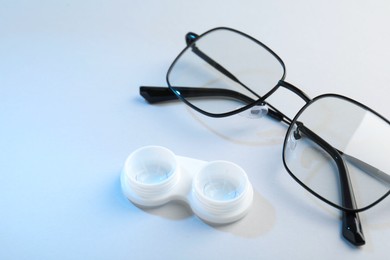 Photo of Case with contact lenses and glasses on white background, closeup