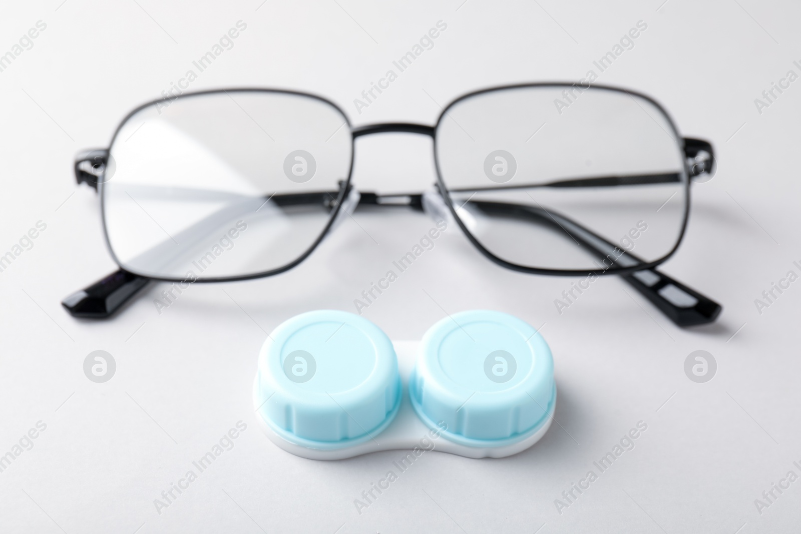 Case with contact lenses and glasses on white background, closeup Photo of Case with contact lenses and glasses on white background, closeup