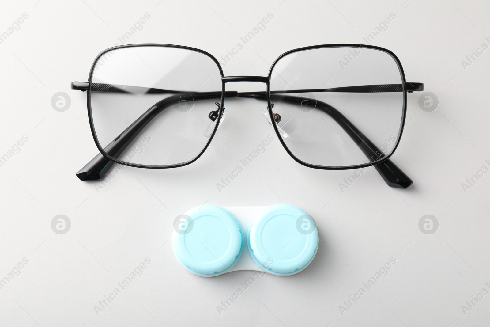 Case with contact lenses and glasses on white background, top view Photo of Case with contact lenses and glasses on white background, top view