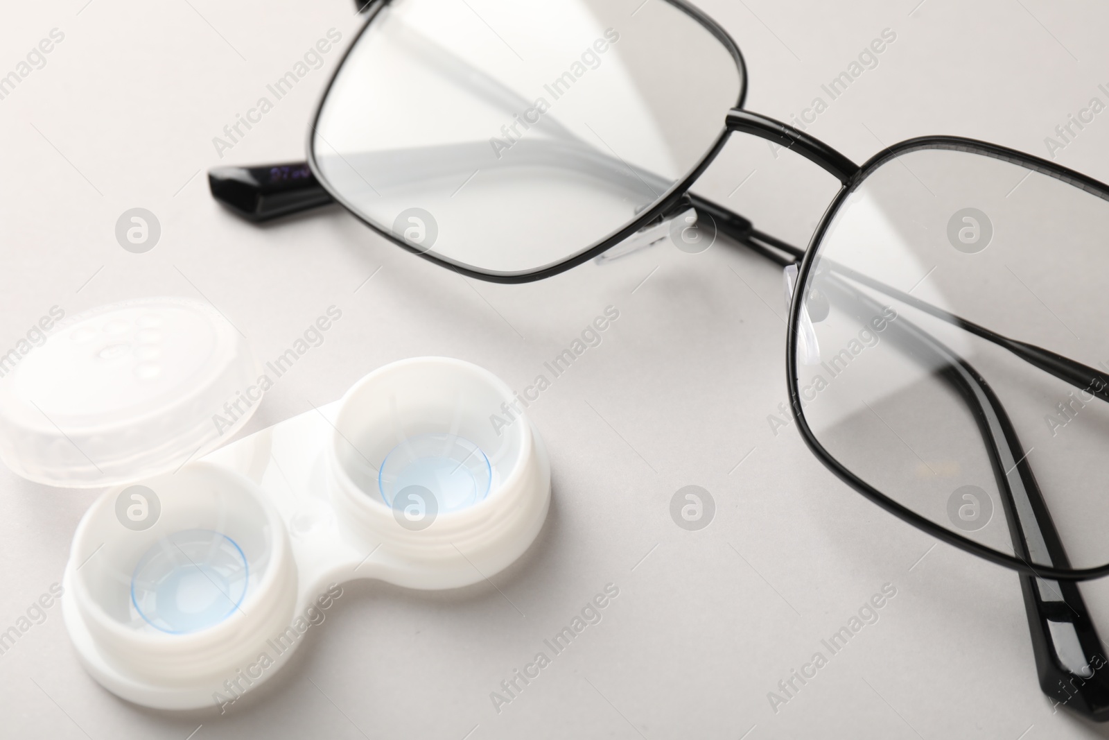 Case with contact lenses and glasses on white background, closeup Photo of Case with contact lenses and glasses on white background, closeup