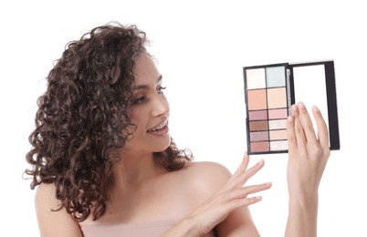 Photo of Smiling woman with eyeshadow palette on white background