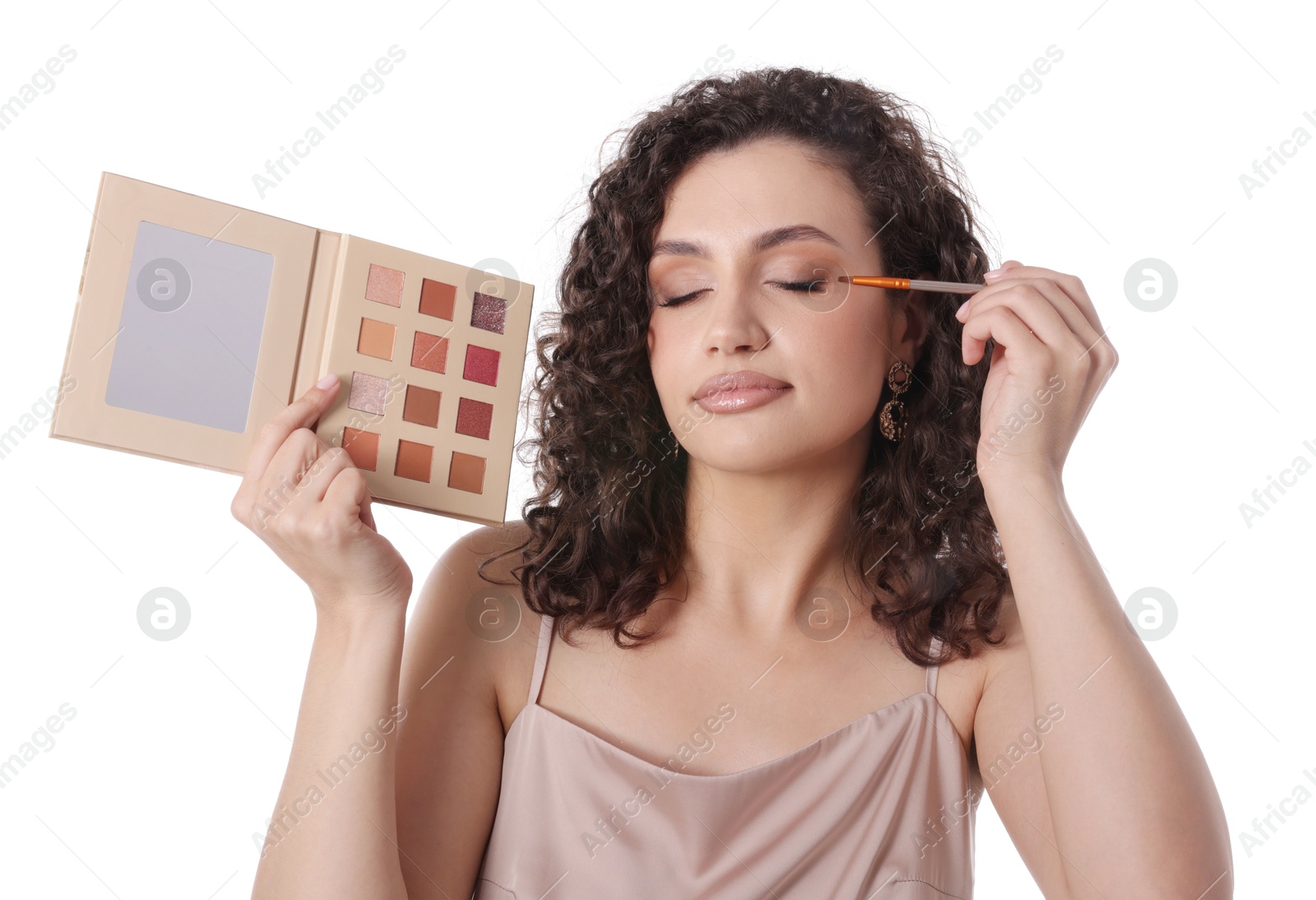 Woman with eyeshadow palette and brush applying makeup on white background Photo of Woman with eyeshadow palette and brush applying makeup on white background