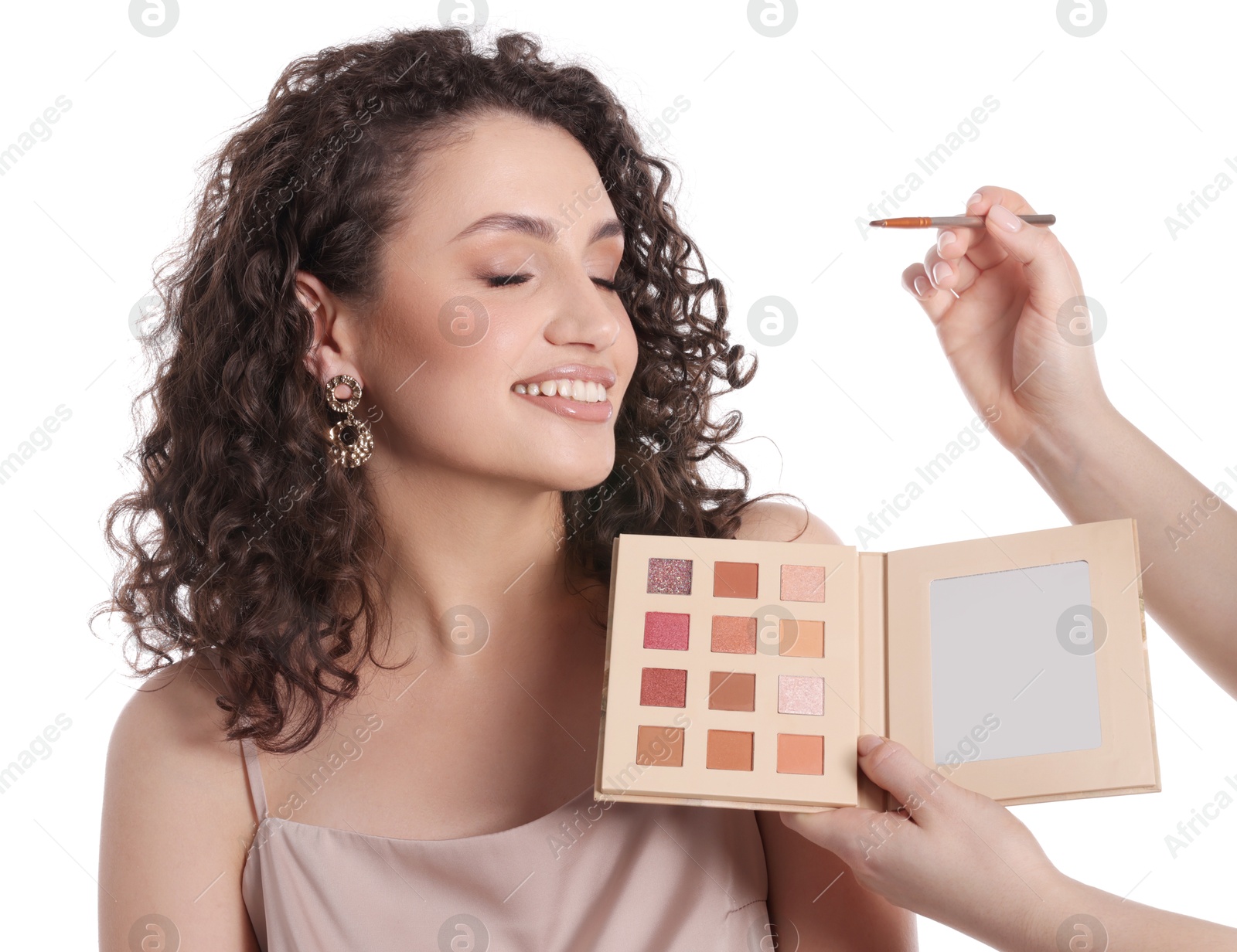 Makeup artist applying eyeshadows onto woman's face on white background, closeup Photo of Makeup artist applying eyeshadows onto woman's face on white background, closeup