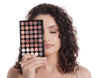 Photo of Woman covering eye with eyeshadow palette on white background