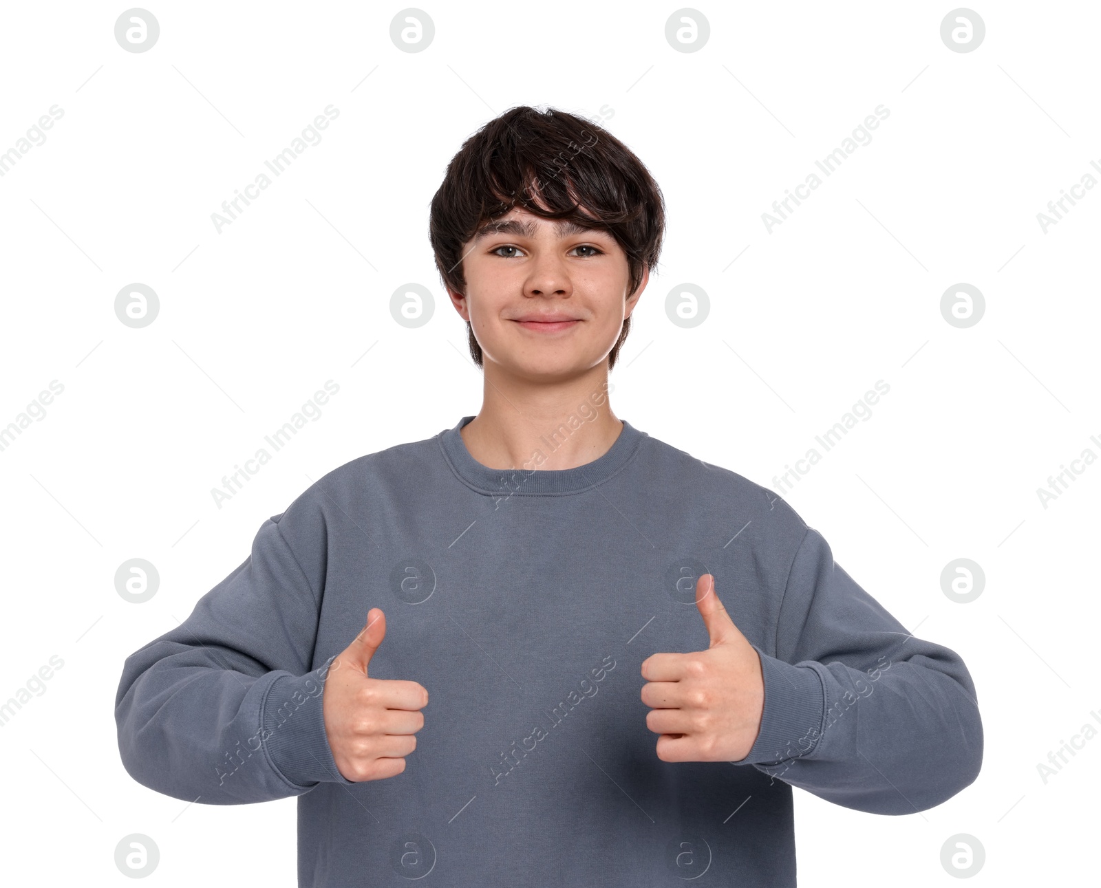 Teenage boy showing thumbs up on white background Photo of Teenage boy showing thumbs up on white background
