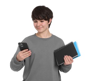 Photo of Teenage boy with smartphone and notebooks on white background