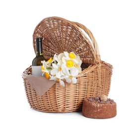 Photo of Picnic wicker basket with beautiful flowers, bottle of wine and cake isolated on white