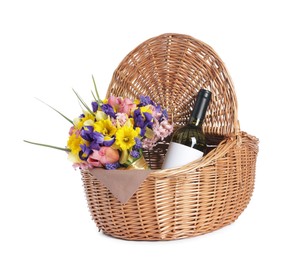 Photo of Picnic wicker basket with beautiful flowers and bottle of wine isolated on white