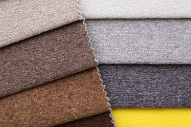 Photo of Samples of different fabrics as background, top view