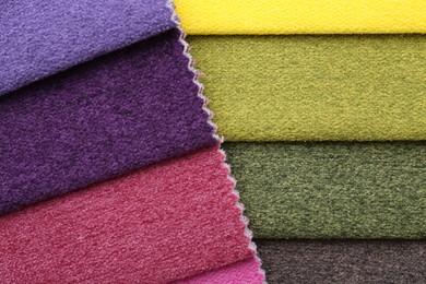 Photo of Samples of different fabrics as background, top view
