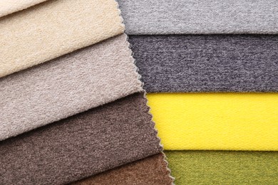 Photo of Samples of different fabrics as background, top view