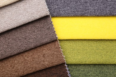 Photo of Samples of different fabrics as background, top view