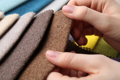 Photo of Woman with samples of different fabrics, closeup
