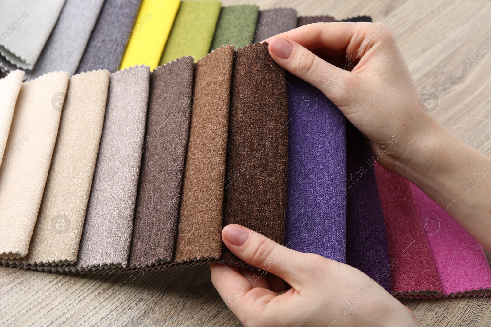 Woman with samples of different fabrics at wooden table, closeup Photo of Woman with samples of different fabrics at wooden table, closeup