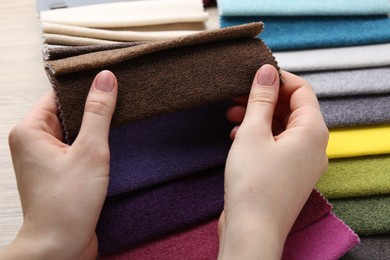 Photo of Woman with samples of different fabrics at table, closeup