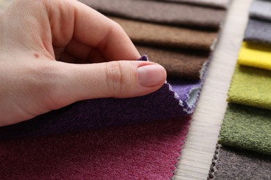 Photo of Woman with samples of different fabrics at wooden table, closeup