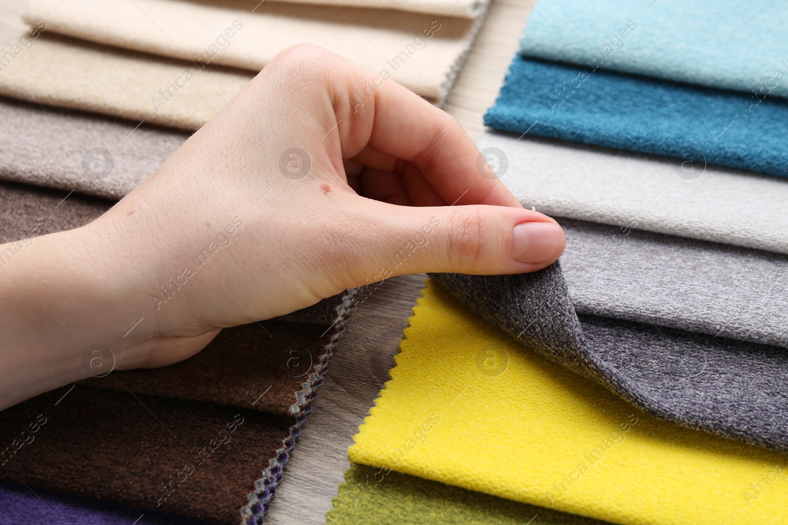 Woman with samples of different fabrics at wooden table, closeup Photo of Woman with samples of different fabrics at wooden table, closeup