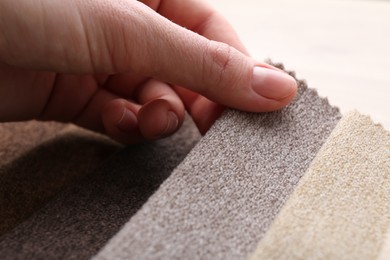 Photo of Woman with samples of different fabrics at table, closeup