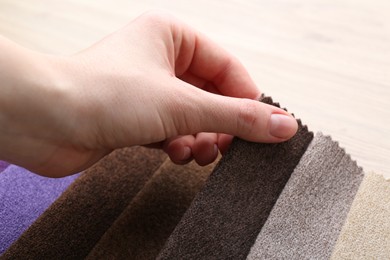 Photo of Woman with samples of different fabrics at table, closeup