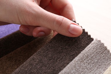 Photo of Woman with samples of different fabrics at table, closeup