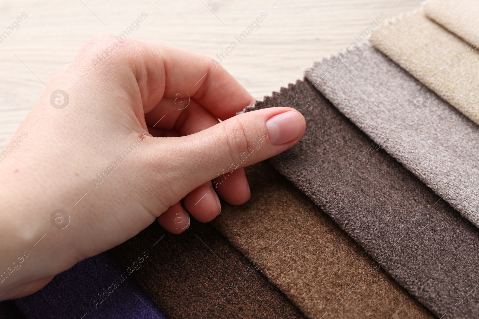 Woman with samples of different fabrics at wooden table, closeup Photo of Woman with samples of different fabrics at wooden table, closeup