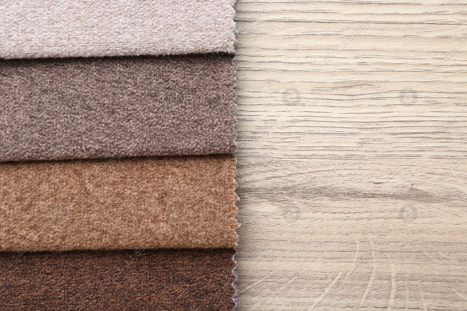 Samples of different fabrics on wooden table, top view. Space for text Photo of Samples of different fabrics on wooden table, top view. Space for text