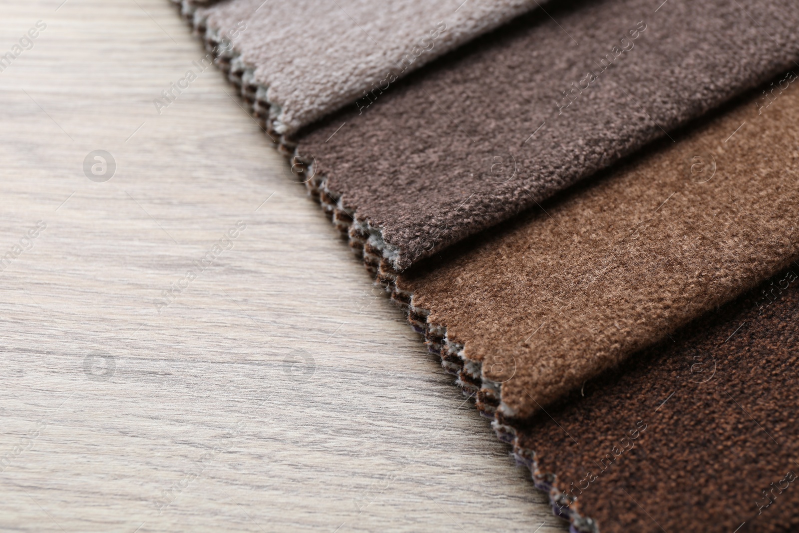 Samples of different fabrics on wooden table, closeup. Space for text Photo of Samples of different fabrics on wooden table, closeup. Space for text