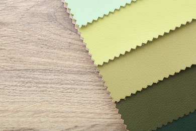 Photo of Samples of different fabrics on wooden table, top view. Space for text
