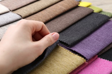 Photo of Woman with samples of different fabrics, closeup