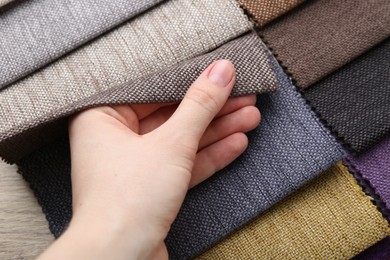Photo of Woman with samples of different fabrics, closeup