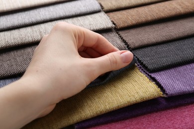 Photo of Woman with samples of different fabrics, closeup