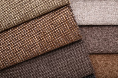 Photo of Samples of different fabrics as background, top view