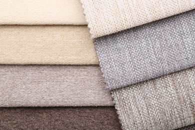 Photo of Samples of different fabrics as background, top view