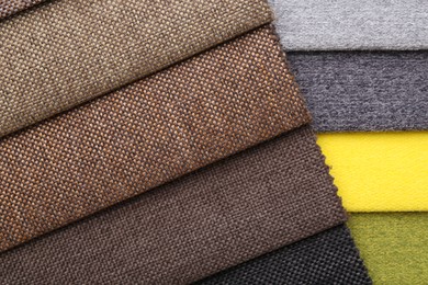Photo of Samples of different fabrics as background, top view