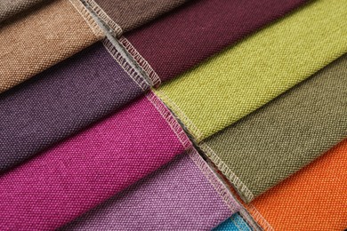 Photo of Samples of different fabrics as background, closeup