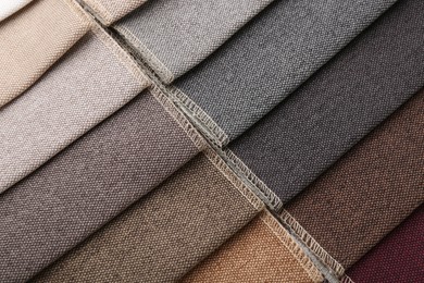 Photo of Samples of different fabrics as background, closeup