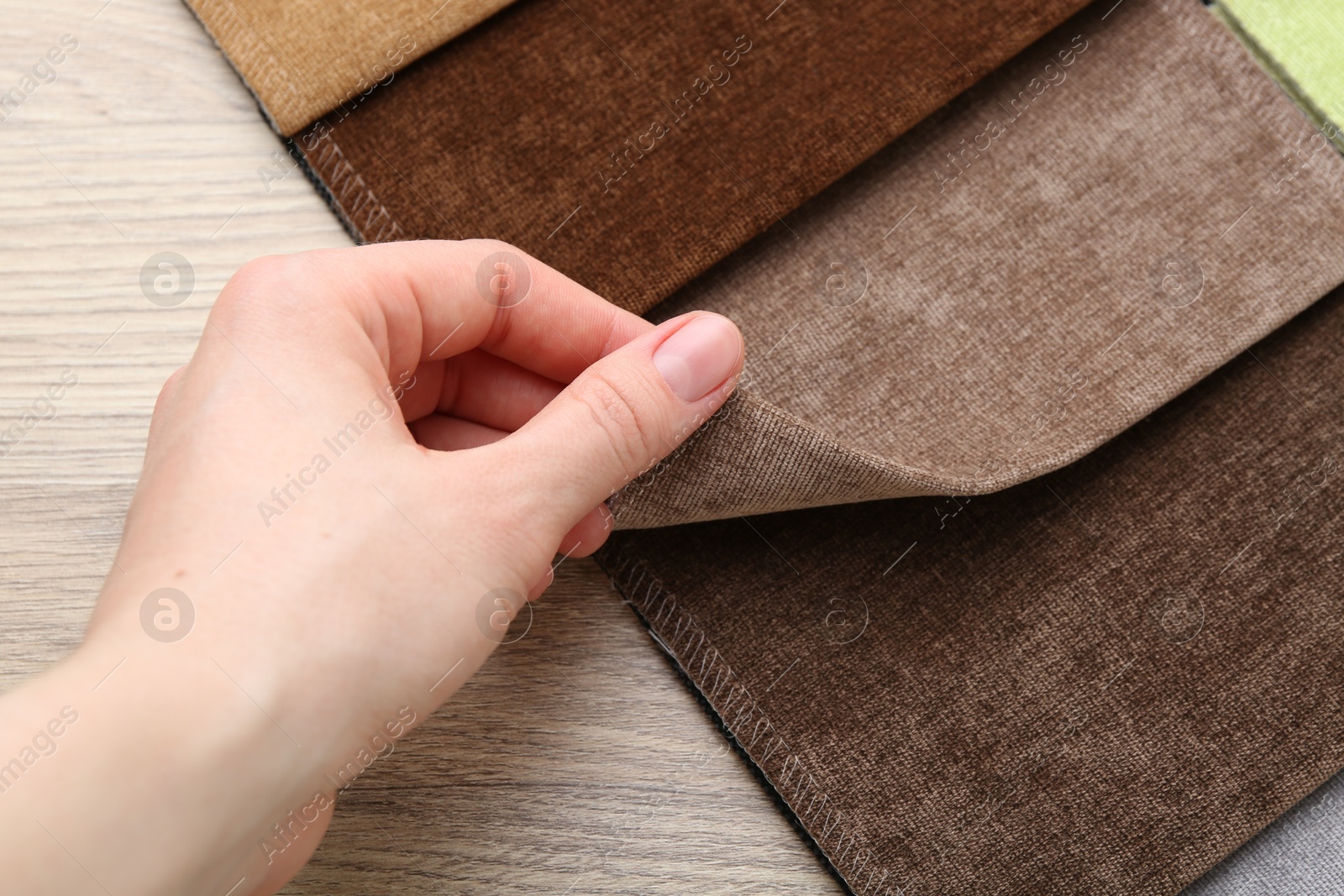 Woman with samples of different fabrics at wooden table, closeup Photo of Woman with samples of different fabrics at wooden table, closeup